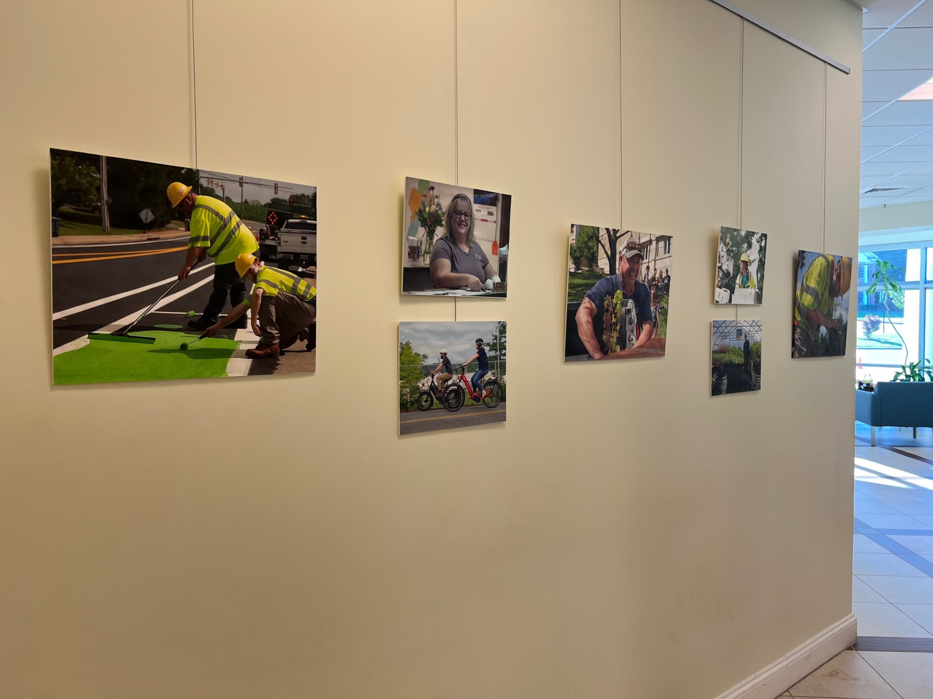 Artwork of employees working hanging in City Hall lobby.