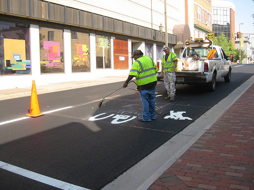 Applying thermoplastic markings with a heat gun.